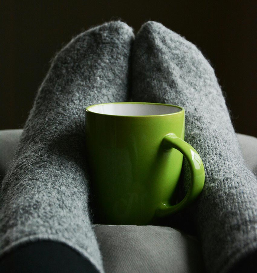 Two feet around cozy cup of tea