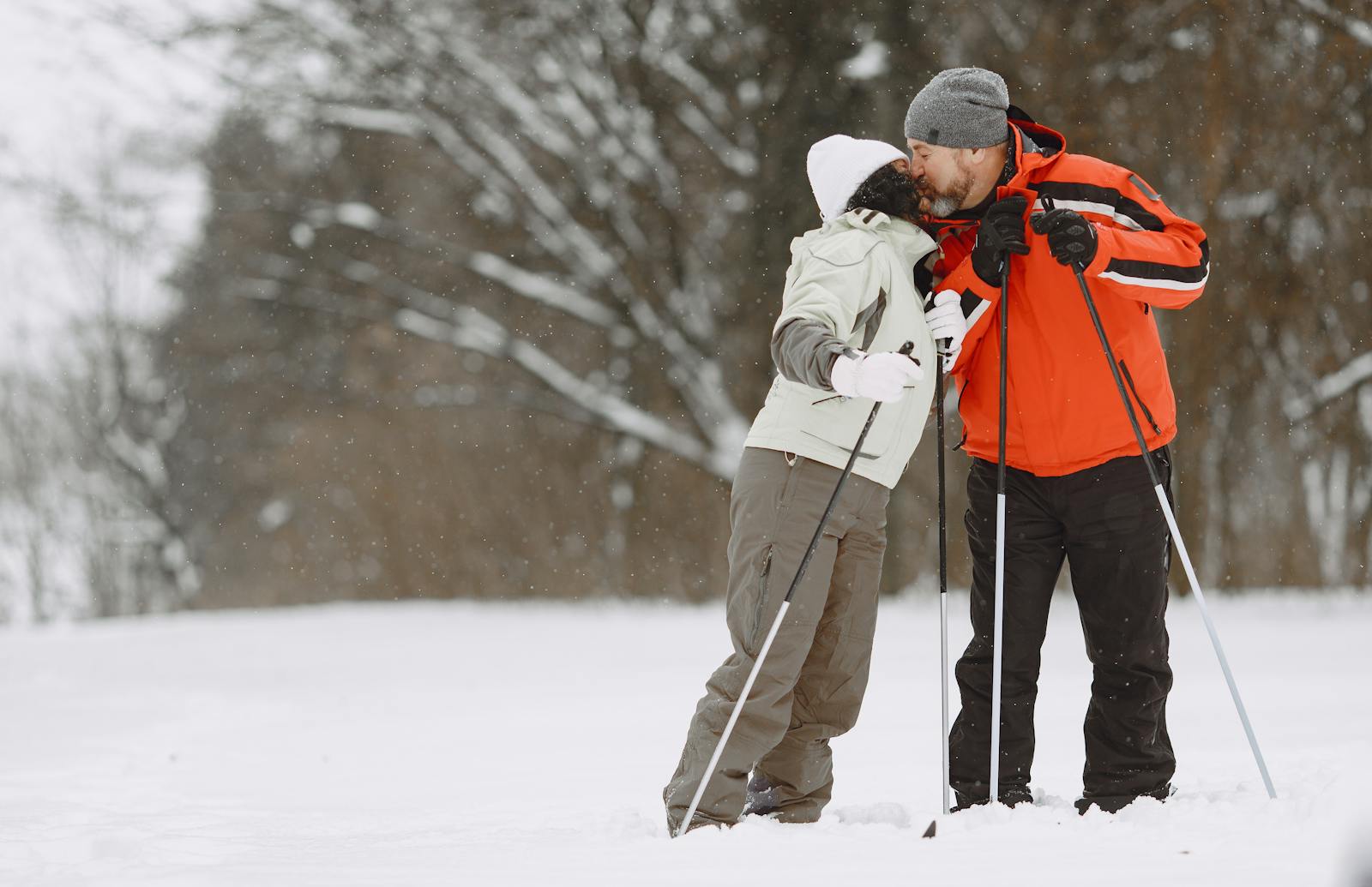 couple kissing in the snow on cross country skis