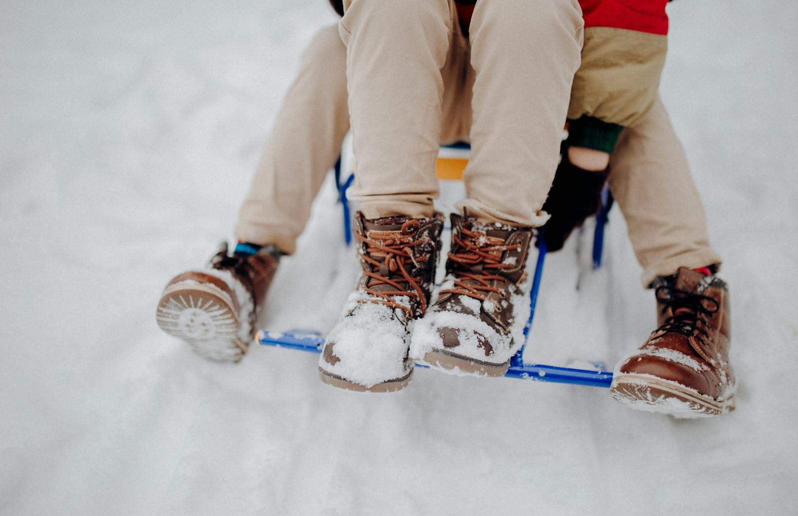 booted childrens' feet on sled