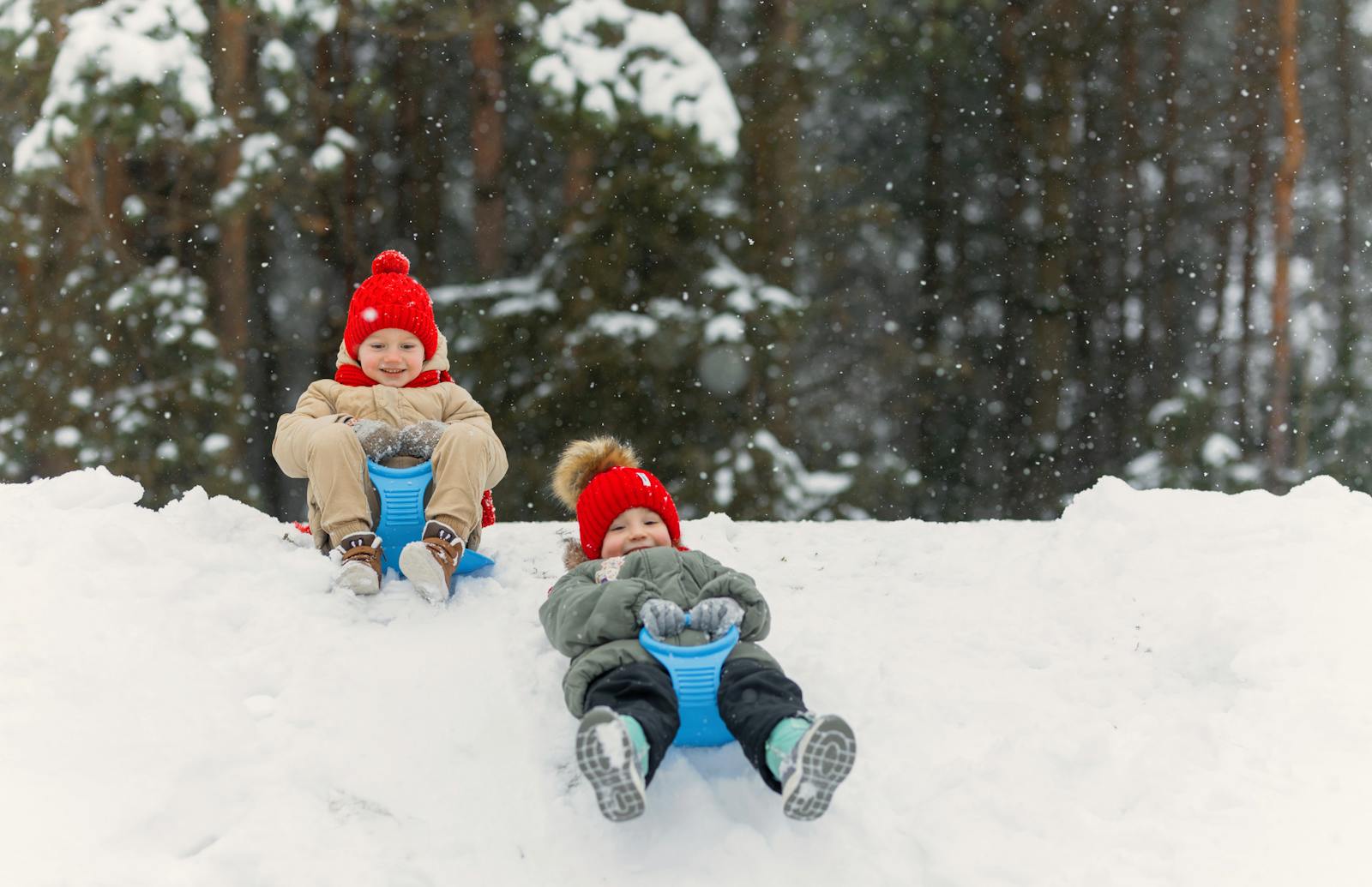 kids in red hats sledding