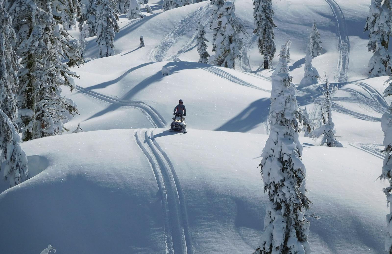 snowmobiling over snowy hills at mt. adams